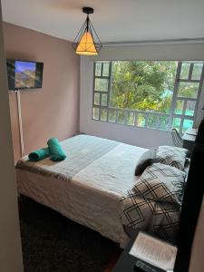 1 dormitorio con cama y ventana grande en Habitación cerca aeropuerto el Dorado en Bogotá