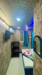 Habitación pequeña con cama y mesa en sun guest house 2, en Ujjain