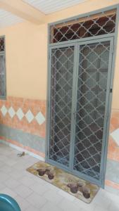 une porte ouverte avec une porte métallique dans une pièce dans l'établissement Manou, à Rivière-Pilote