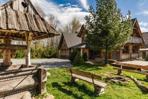 a yard with benches and a wooden building at Chata Nad Jeziorem in Maniowy