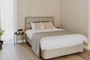 a bedroom with a large bed with white sheets and pillows at Cukura Loft in Jelgava