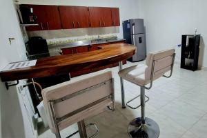 a kitchen with a wooden counter and two chairs at Medellín Casa central Envigado frontera poblado in Envigado