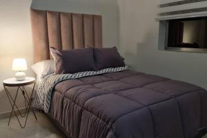 1 dormitorio con 1 cama grande con almohadas moradas en Medellín Casa central Envigado frontera poblado en Envigado