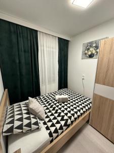 a bedroom with a black and white checkered bed at Apartman ZEN in Popovača