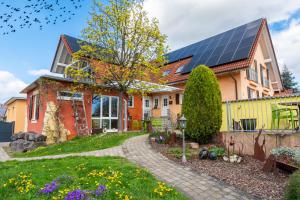 une maison avec des panneaux solaires sur le toit dans l'établissement Hotel & Gästehaus Im Ziegelweg KLIMATISIERT Eintrittskarten für den Europa-Park erhalten Sie garantiert über uns, à Rust