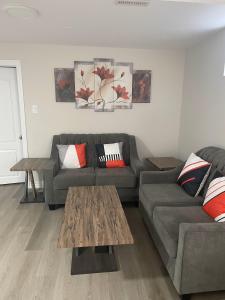 a living room with a couch and a table at Brand New, cozy 2 Bdrm Bsmnt Apt in Mississauga