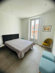 a bedroom with a bed and a chair and a window at Appartement port de Sanary in Sanary-sur-Mer
