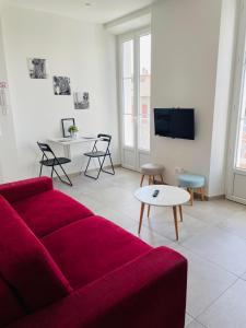 a living room with a red couch and a table at Appartement port de Sanary in Sanary-sur-Mer