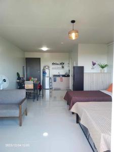 Una sala de estar con dos camas y una cocina. en Cozy Studio with pool, en Puerto Princesa City
