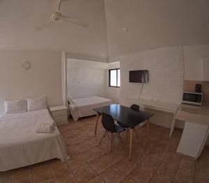 a bedroom with a bed and a desk and a table at Hotel El Legendario in Sosúa