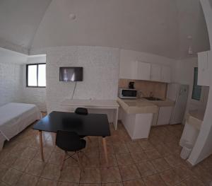 a bedroom with a bed and a kitchen with a table at Hotel El Legendario in Sosúa