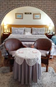a bedroom with a bed with two chairs and a table at Lily's Cottage in Durban