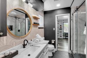 a bathroom with a sink and a mirror and a toilet at 10min to EXPO - Family-Friendly with Office & Playroom in Tulsa +34 photos