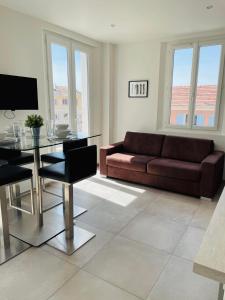 a living room with a couch and a glass table at Appartement port de Sanary in Sanary-sur-Mer