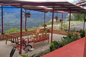 uma bicicleta estacionada sob um pavilhão com um banco e uma mesa em Cabaña Panorámica - Chachapoyas em Chachapoyas