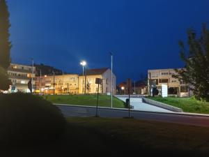 a city street at night with buildings and street lights at Apartman ZEN in Popovača