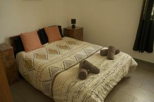 un dormitorio con una cama con dos animales de peluche en Esperjenza Apartment St Julians, en Paceville