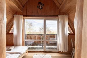 a bedroom with a large window in a wooden house at Chata Nad Jeziorem in Maniowy