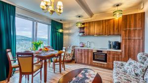 Apartament nad Elementsem 29 - 5D Apartamenty في شيراردوف ازدروي: مطبخ وغرفة طعام مع طاولة وكراسي