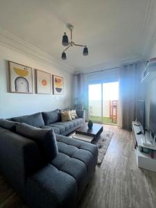 a living room with a couch and a tv at Ocean view sunset apartment in the heart of Rabat in Rabat