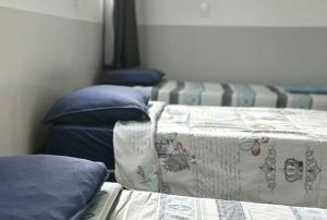 een slaapkamer met 2 bedden en blauwe kussens bij Hotelcity in Brusque