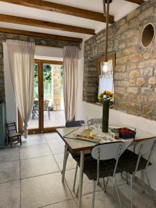 a dining room with a table and a stone wall at Istrian green house in Portorož