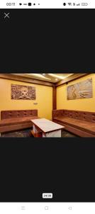 two pictures of a room with a table and benches at Hotel Ashok Vihar in Bhabua