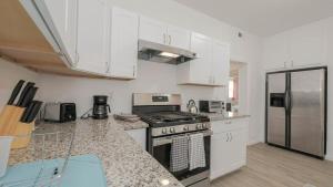 a kitchen with a stove and a refrigerator at Escape to Raleigh Ave 3 Steps from the Beach in Atlantic City