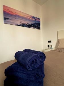 a pile of blue towels sitting on top of a bed at Lighthouse in Puerto del Rosario