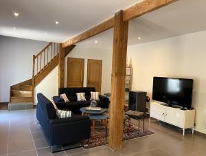 un soggiorno con un divano e una TV di Grand gîte Gastes a Gastes