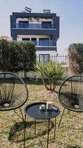 dos sillas y una mesa frente a un edificio en DiaMar, en Kallithea Halkidikis
