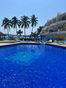 a large blue swimming pool next to a resort at Departamento familiar con vista al mar in Manzanillo