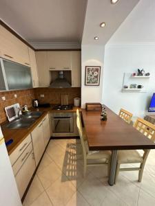uma cozinha com uma mesa de madeira e um lavatório em Henry’s beach apartment em Golem