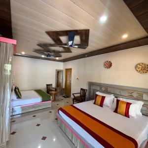 a bedroom with two beds and a ceiling at Rocky Mountain homestay in Dalhousie