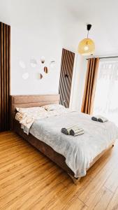 een slaapkamer met een bed met twee slippers erop bij Luxury apartament Buiucani in Chişinău