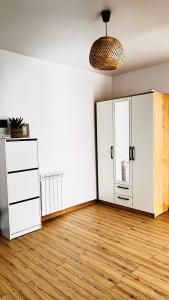 an empty living room with white cabinets and wood floors at Luxury apartament Buiucani in Chişinău