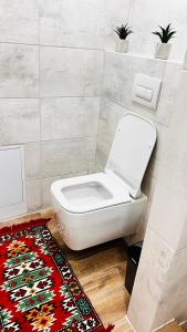 een badkamer met een toilet en een tapijt bij Luxury apartament Buiucani in Chişinău