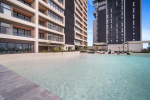 an empty swimming pool in a building with tall buildings at BALTIA Luxurious One Bedroom Ap in Mérida