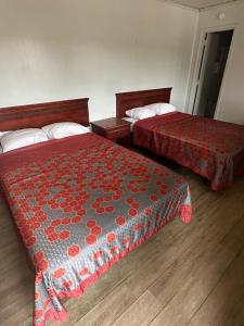 Habitación de hotel con 2 camas con sábanas rojas en Travel Inn Montgomery AL en Montgomery