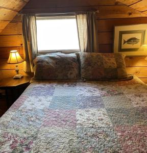 ein Schlafzimmer mit einem Bett mit einer Decke darauf in der Unterkunft Cozy Cottage on Pond in Great Valley