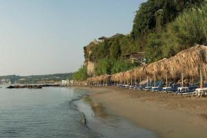 a beach with a bunch of chairs and umbrellas at Ανεμώνη - Anemoni in Koroni