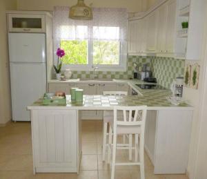a white kitchen with a white refrigerator and a counter at Ανεμώνη - Anemoni in Koroni