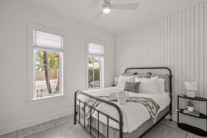 a white bedroom with a bed and two windows at NEW! Casa Monte Cristo - Upscale Ybor Townhome in Tampa