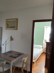 ラヴァーニャにあるCOME a CASA TUA - LAVAGNAのテーブル、ベッド、鏡が備わる客室です。