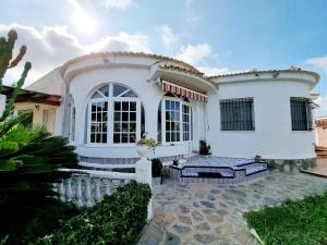 a white house with a fence in front of it at Charming Villa With Own Pool Urb La Siesta in La Mata