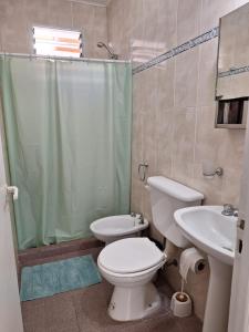 a bathroom with a toilet and a sink and a shower at Departamentos MR in Villa Elisa +14 photos