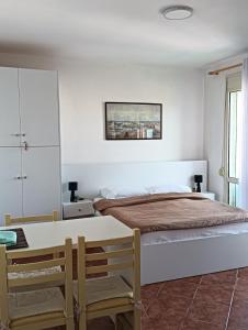 een witte slaapkamer met een bed en een tafel bij Seaside Deluxe Apartment in Durrës