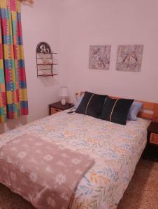 - une chambre avec un lit et une couette colorée dans l'établissement Casa Refugio Entre Pinos y Romeros, à Mogente