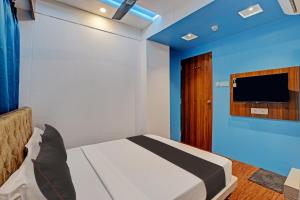 1 dormitorio con 1 cama y TV en la pared en Hotel Ocean Inn Near Delhi Airport en Nueva Delhi