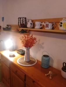 un vase avec des fleurs sur un meuble en bois dans l'établissement Casa Refugio Entre Pinos y Romeros, à Mogente